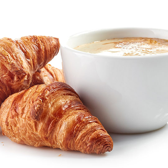 eine Kaffeetasse und Croissants